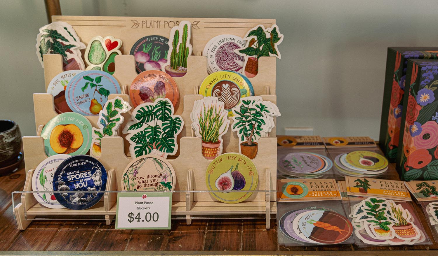 Plant Posse stickers showcased on a wooden stand