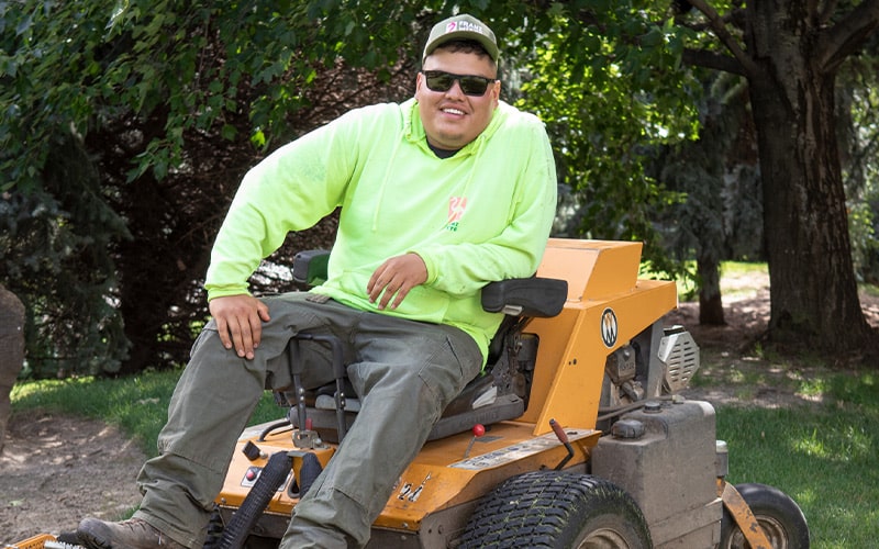 Photo of Franz Witte employee sitting on yellow lawn mower